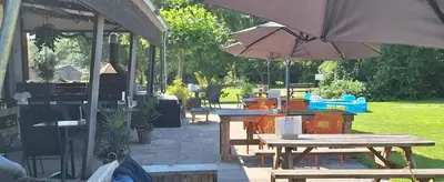 a patio with picnic tables and an umbrella at Rekerlanden 260 in Schoorldam