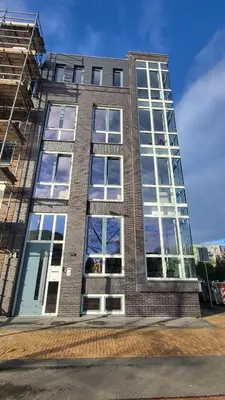 a tall brick building with lots of windows at B&B Kopwest 1 in Purmerend