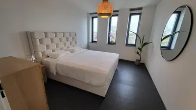 a bedroom with a large bed and a mirror at B&B Kopwest 2 in Purmerend