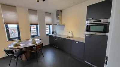 a kitchen with a table and a sink and a stove at B&B Kopwest 2 in Purmerend