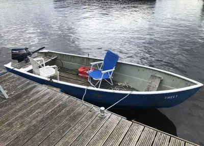 a blue boat with a blue chair sitting on a dock at Een luxe safari tent in Rijsenhout