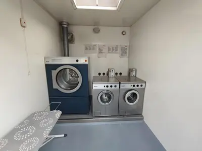 a laundry room with two washing machines and a window at Floating Holiday Home - 15 mins to AMS in Vinkeveen