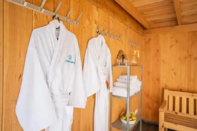 a room with white towels hanging on a wooden wall at Trio Lodge in Zeewolde