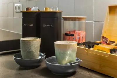 two cups sitting on a counter next to a container at Unique underground hotel in Utrecht city center in Utrecht