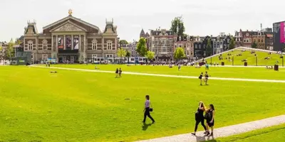 a group of people walking in a field in front of a building at Museum district, beautiful renovated house in Amsterdam