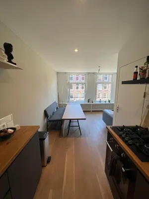 a kitchen and living room with a couch and a table at Museum district, beautiful renovated house in Amsterdam