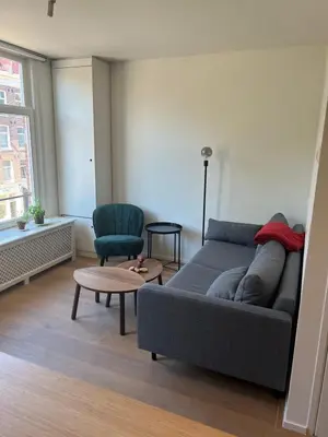 a living room with a couch and a chair at Museum district, beautiful renovated house in Amsterdam