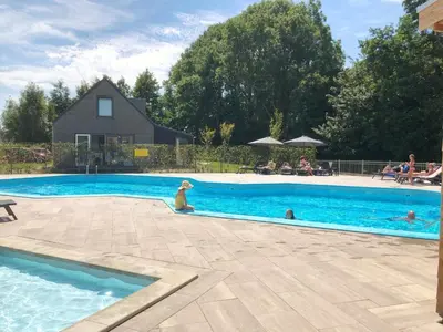 a dog is sitting in a swimming pool at Vakantiehuis voor mindervaliden op Recreatiepark De Wielen - 61 in Sint Maarten