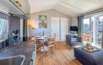 a kitchen and living room with a table and a couch at Nice Home In Breukelen in Breukelen