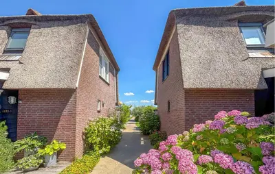 two brick buildings with flowers in front of them at Nice Home In Breukelen in Breukelen