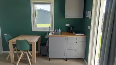 a kitchen with a sink and a table and a window at Recreatie aan de Vecht, Hooibergje 2, Weesp in Weesp