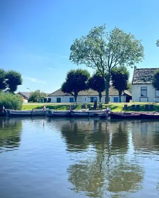 a group of boats are docked on a river at Recreatie aan de Vecht, Hooibergje 3, Weesp in Weesp