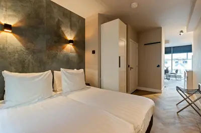 a bedroom with a large white bed with white pillows at Midtown Hotel triple in Amsterdam