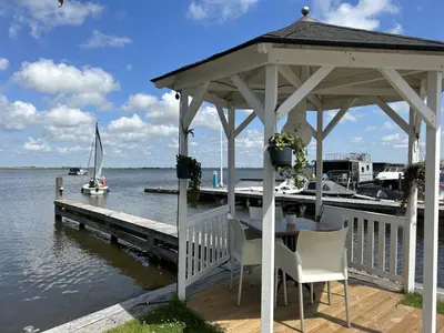 a gazebo with a table and chairs on a dock at Apartment Oostergeest 2 by Interhome in Uitgeest