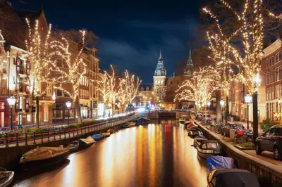 a city at night with christmas lights and a canal at Manor Suite Amsterdam in Amsterdam