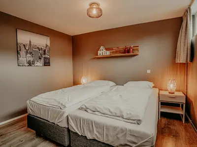 a bedroom with a bed and a shelf on the wall at Houseboat Woude Uitgeest in Uitgeest