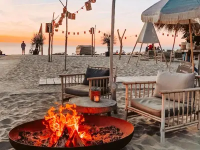 a fire pit on the beach at sunset at Holiday Home Hollandsche Tulp by Interhome in Noordwijkerhout
