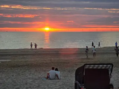 a group of people on the beach at sunset at LÖYLY Egmond in Egmond aan Zee