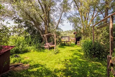 a garden with two benches and a swing at farmhouse in Wijdewormer