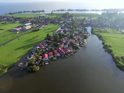an aerial view of a group of houses and a river at Holiday Home Schönes Ferienhaus in Wervershoof mit Garten- Grill und Terrasse by Interhome in Wervershoof