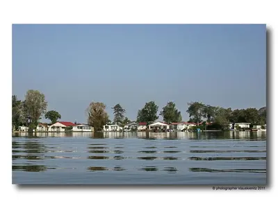 a large body of water with houses in the background at Holiday Home Chalet op Zee by Interhome in Wervershoof