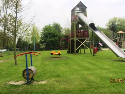 a playground with a slide in a park at Apartment Familienfreundliches Ferienhaus Angel mit Garten by Interhome in Wervershoof