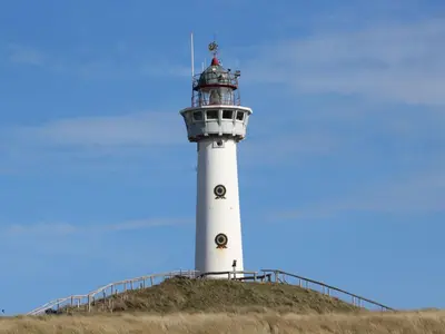 a white lighthouse on top of a hill at Holiday Home De Zeeparel by Interhome in Egmond aan Zee