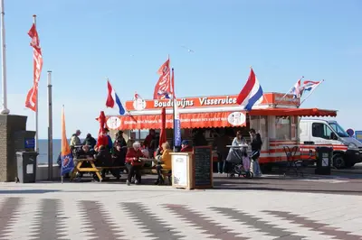 a food truck with people sitting outside of it at Reumann Holiday Apartments De Schelp 5 in Zandvoort
