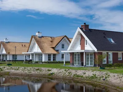 a row of houses next to a body of water at Holiday Home Alk 6 by Interhome in Noordwijk