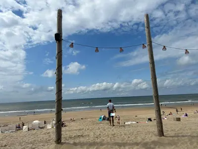 a man standing on the beach looking at the ocean at Holiday Home Alk 6 by Interhome in Noordwijk