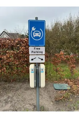 a free parking sign with arrows on a pole at Holiday Home Alk 6 by Interhome in Noordwijk