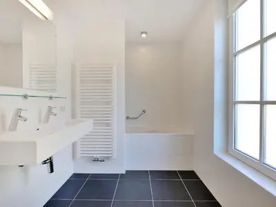 a white bathroom with a sink and a tub at Holiday Home Tapuit 8-1 by Interhome in Noordwijk
