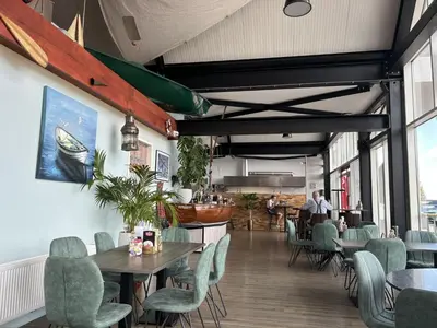 a restaurant with tables and chairs and people in the background at Holiday Home Dorregeest-1 by Interhome in Uitgeest