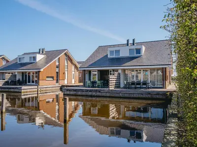 a row of houses on a body of water at Apartment in Egmond aan Zee near the Beach in Egmond aan Zee