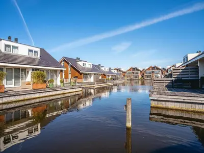 a row of houses and a canal with houses at Apartment in Egmond with Stunning Sea Views in Egmond aan Zee