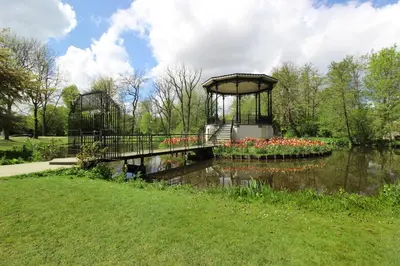 a bridge over a pond with flowers in a park at Guesthouse Prinsencanal 2 in Amsterdam