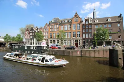 a boat traveling down a river in a city at Guesthouse Prinsencanal 2 in Amsterdam