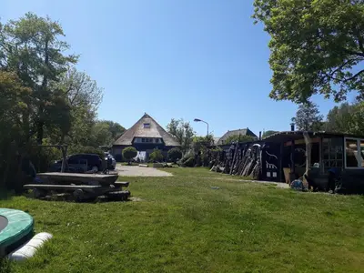 a yard with a barn and a field of grass at de Vrijheid in Groet