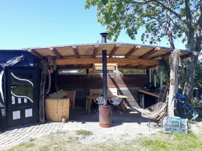 a wooden pergola with a table and a swing at de Vrijheid in Groet