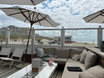 a living room with a couch and an umbrella at Holiday Home Plevier Comfort-2 by Interhome in Noordwijk