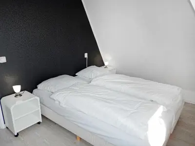 a bed with white sheets and two lamps on it at Holiday Home Plevier Comfort-2 by Interhome in Noordwijk