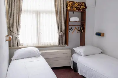 two beds in a room with a window at Hotel Ben Centre in Amsterdam