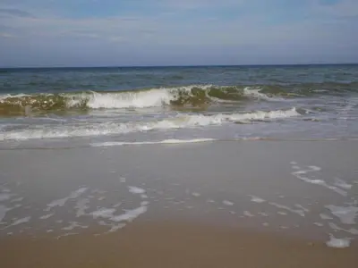 a sandy beach with waves in the ocean at Apartment in North Holland in Bergen aan Zee