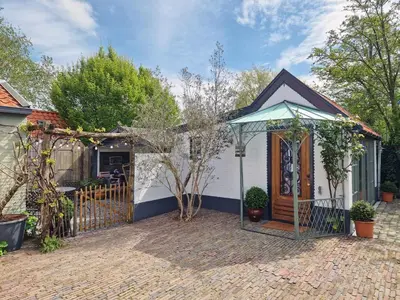 a house with a gate and a fence at Bed & Bentwoud in Benthuizen