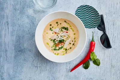 a bowl of soup on a table with a red pepper at Bunk Hotel Amsterdam in Amsterdam