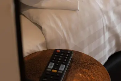 a remote control sitting on a table next to a bed at Midtown Hotel Twin Studio in Amsterdam