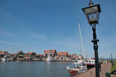 a street light next to a body of water with boats at Appartement Volendam in Volendam