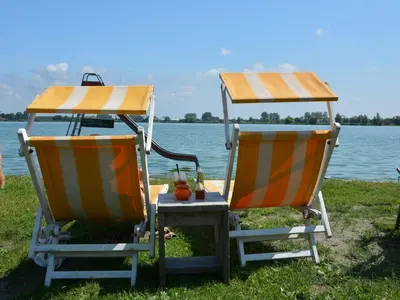 two beach chairs sitting next to a body of water at Bungalow in Noordwijk near Lake & Beach in Noordwijkerhout