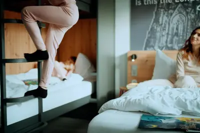 a woman is sitting on a bunk bed at MEININGER Hotel Amsterdam City West in Amsterdam
