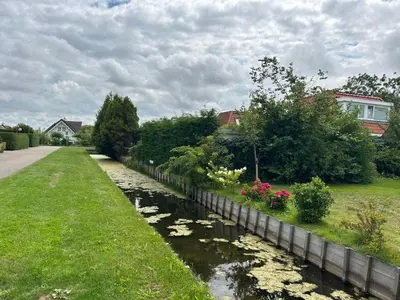 a river with plants and flowers in a yard at Holiday Home Plevier Comfort-3 by Interhome in Noordwijkerhout